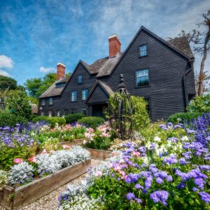 Exterior image of The House of the Seven Gables with the garden in full bloom