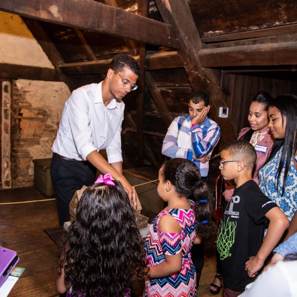 A guide shares information with visitors in the attic of The House of the Seven Gables