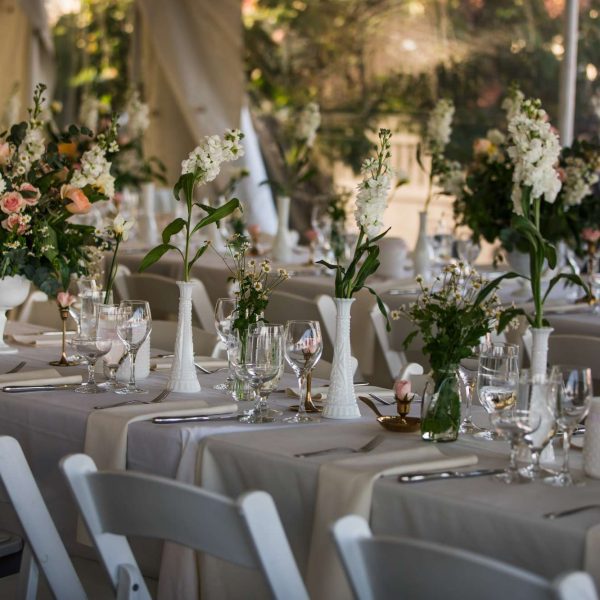 Photo of a long table on the seaside lawn with flower centerpieces for a wedding at The House of the Seven Gables.