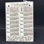 ceramic with an image of a house printed in brown|small ceramic tile with a calendar for 1929 printed in brown
