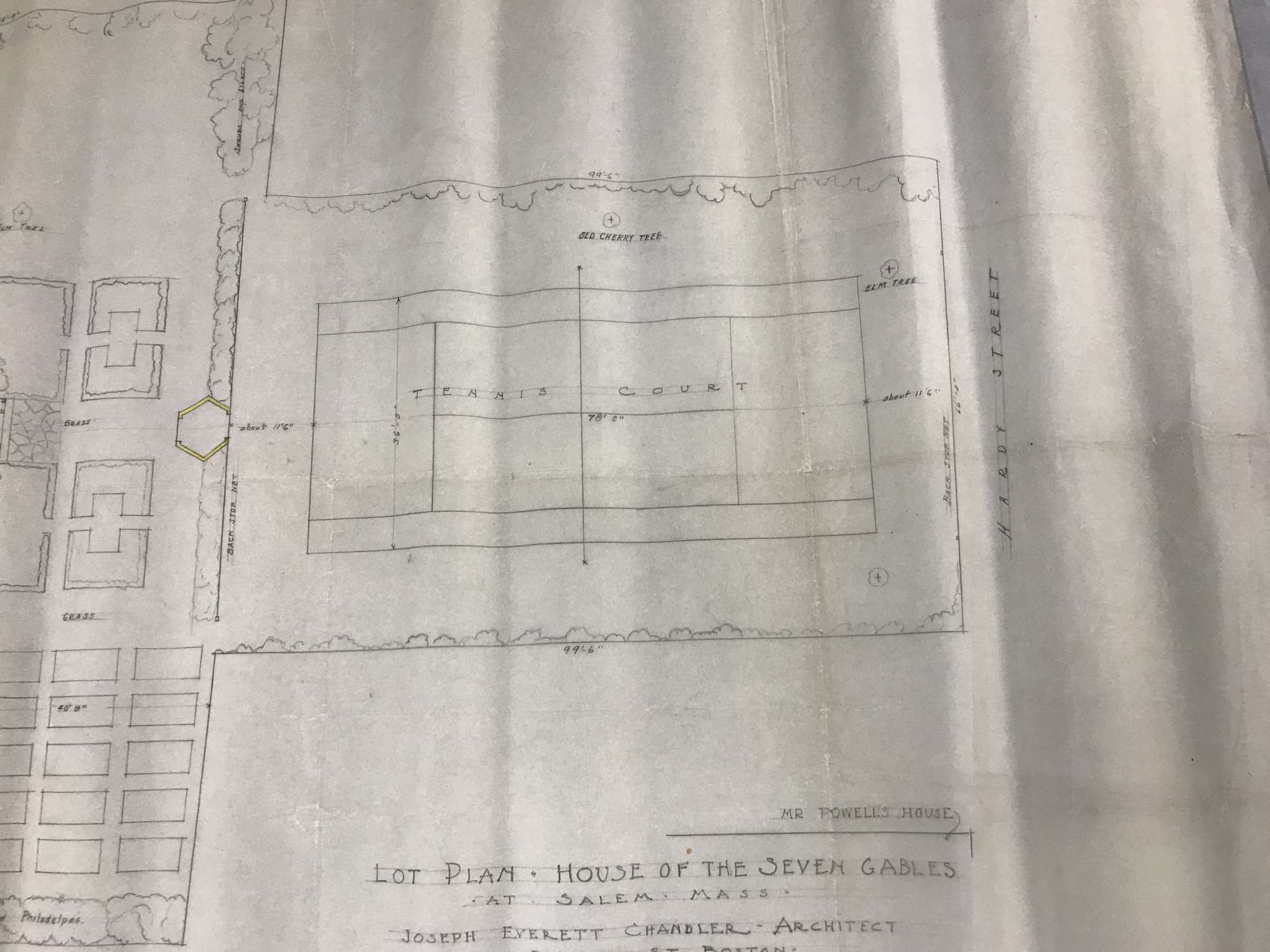 Worn label on the edge of a set of blueprints|writing in pencil between stenciled lines|blueprint with color coded walls and information|plan for a garden|plan for a tennis court