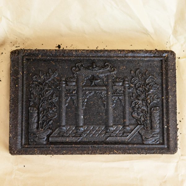 Front view of an unwrapped black tea brick.