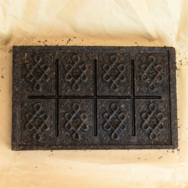 Back view of an unwrapped black tea brick.