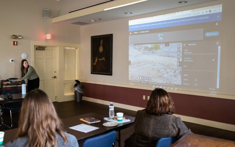 People look at a projected image during a lecture on the climate change initiatives at the Gables.
