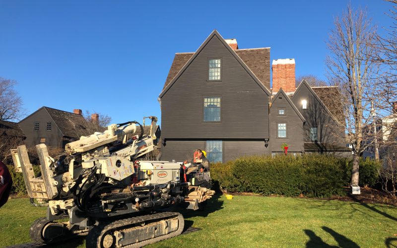 A large piece of machinery sits on the lawn of the Gables with The House of the Seven Gables in the background.